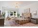 Bright main bedroom features a plush bed, a sitting area with a couch, and views of the yard at 12620 N 70Th St, Scottsdale, AZ 85254