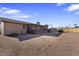 View of the backyard with gravel, partial block wall, and covered back porch at 1459 S Mara Dr, Apache Junction, AZ 85120