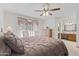 Main bedroom with a ceiling fan, window, dresser, and ensuite bathroom entrance at 1459 S Mara Dr, Apache Junction, AZ 85120