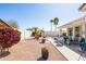 The backyard features desert landscaping, a covered patio, and a seating area perfect for outdoor living at 15516 W Verde Ln, Goodyear, AZ 85395