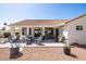 Expansive backyard featuring a covered patio, outdoor seating, BBQ grill, and well-maintained landscaping at 15516 W Verde Ln, Goodyear, AZ 85395