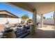 Relaxing backyard patio area with stylish outdoor furniture, landscaped yard, and ample space for entertaining at 15516 W Verde Ln, Goodyear, AZ 85395