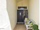 Charming front entrance featuring a decorative door and a cozy bench with pillows and potted plant at 15516 W Verde Ln, Goodyear, AZ 85395
