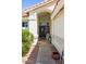 Inviting front entrance with an arched doorway, black front door, and charming landscaping at 15516 W Verde Ln, Goodyear, AZ 85395