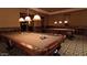 Well-appointed game room featuring billiard tables with custom lighting and handsome millwork at 15516 W Verde Ln, Goodyear, AZ 85395