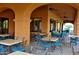 Outdoor patio space with tables, chairs, and view of landscaping at 15516 W Verde Ln, Goodyear, AZ 85395