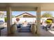 Inviting outdoor patio featuring comfortable seating, decorative urns, and a view of the landscaped backyard at 15516 W Verde Ln, Goodyear, AZ 85395