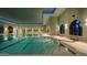 Indoor pool with blue-lit recessed lighting and curved windows at 15516 W Verde Ln, Goodyear, AZ 85395