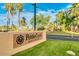 The PebbleCreek Resort Community entrance sign is surrounded by lush greenery and palm trees at 15516 W Verde Ln, Goodyear, AZ 85395