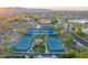 Aerial view of community tennis courts in a neighborhood with mature trees at 15516 W Verde Ln, Goodyear, AZ 85395