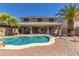 Spacious backyard boasts a refreshing pool, covered patio, and mature palm trees creating the perfect outdoor retreat at 15604 N 173Rd Ln, Surprise, AZ 85388