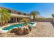 Beautiful backyard features a pool, lush palm trees, covered patio, and ample space for entertaining at 15604 N 173Rd Ln, Surprise, AZ 85388