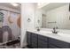 Modern bathroom with a double sink vanity, large mirror, and shower curtain at 15604 N 173Rd Ln, Surprise, AZ 85388