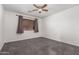 Empty bedroom featuring carpet flooring, a ceiling fan, and window at 15604 N 173Rd Ln, Surprise, AZ 85388