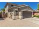 Exterior view of the property with a two-car garage, desert landscaping, and a secure fenced entry at 15604 N 173Rd Ln, Surprise, AZ 85388