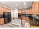 Bright kitchen with stainless steel fridge, granite counters, wood cabinets, island and tile backsplash at 15604 N 173Rd Ln, Surprise, AZ 85388