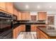 Kitchen featuring wood cabinets, granite counters, stainless appliances, dishwasher and double oven at 15604 N 173Rd Ln, Surprise, AZ 85388