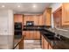 Kitchen with wood cabinets, stainless appliances, granite counters, undermount sink and tile backsplash at 15604 N 173Rd Ln, Surprise, AZ 85388