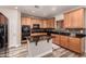 Well-lit kitchen with stainless steel appliances, granite counters, wood cabinets and an island at 15604 N 173Rd Ln, Surprise, AZ 85388