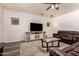 Comfortable living room featuring a large television, leather seating, and a stylish ceiling fan at 15604 N 173Rd Ln, Surprise, AZ 85388