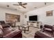 Cozy living room featuring comfortable leather seating, a ceiling fan, and a modern entertainment center at 15604 N 173Rd Ln, Surprise, AZ 85388