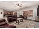 Spacious living room showcasing a leather sofa set, a ceiling fan, and an open layout to the kitchen at 15604 N 173Rd Ln, Surprise, AZ 85388