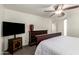 Main bedroom with a ceiling fan, TV and a dresser plus a connecting door to the bathroom at 15604 N 173Rd Ln, Surprise, AZ 85388