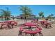 Community picnic area featuring red tables, mature trees, and walking paths, providing a great outdoor gathering space at 15604 N 173Rd Ln, Surprise, AZ 85388