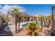 Beautiful backyard with a refreshing pool, mature palm trees, and solar panels on the house at 15903 N 138Th Ave, Surprise, AZ 85374