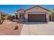 Home exterior with brick accents on front porch and desert landscaping for low maintenance living at 15903 N 138Th Ave, Surprise, AZ 85374