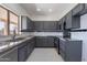 Modern kitchen featuring granite countertops, stainless steel appliances, and gray cabinetry at 15903 N 138Th Ave, Surprise, AZ 85374