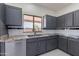 Updated kitchen with granite countertops, stainless steel appliances, and gray cabinets at 15903 N 138Th Ave, Surprise, AZ 85374
