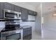 This kitchen features stainless steel appliances, dark gray cabinetry, and granite countertops at 15903 N 138Th Ave, Surprise, AZ 85374