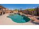 Sparkling pool with rock waterfall feature, surrounded by lush landscaping and mature palm trees at 15903 N 138Th Ave, Surprise, AZ 85374