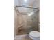 Shower enclosed with a glass door featuring travertine tile and a built in seat at 15903 N 138Th Ave, Surprise, AZ 85374