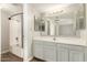 Bathroom features white cabinets, a large mirror and tub with shower at 1616 S Torre Molinos Cir, Tempe, AZ 85281