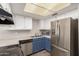 View of the kitchen with stainless steel appliances, white cabinets, and modern lighting at 1616 S Torre Molinos Cir, Tempe, AZ 85281
