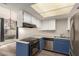 View of the kitchen with stainless steel appliances, white cabinets, and modern lighting at 1616 S Torre Molinos Cir, Tempe, AZ 85281