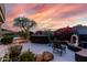 Landscaped backyard with a built-in grill, seating area, and vibrant bougainvillea under a colorful sky at 16670 N 109Th Way, Scottsdale, AZ 85255