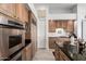 Well-lit kitchen featuring wood cabinets, stainless steel appliances, and black granite countertops at 16670 N 109Th Way, Scottsdale, AZ 85255