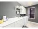 Well-lit laundry room featuring ample counter space, white cabinets, and modern appliances at 16670 N 109Th Way, Scottsdale, AZ 85255