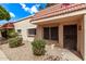 Tan townhome featuring a red tile roof, security bars on windows, and drought-tolerant landscaping at 17242 N 16Th Dr # 6, Phoenix, AZ 85023