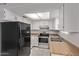 Well-lit kitchen with white cabinets, a black refrigerator, and stainless steel oven for efficient cooking at 17242 N 16Th Dr # 6, Phoenix, AZ 85023
