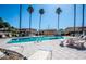 Relaxing community pool with clear blue water, lounge chairs, and tall palm trees set under a beautiful blue sky at 17242 N 16Th Dr # 6, Phoenix, AZ 85023