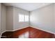 Cozy bedroom featuring dark wood flooring, neutral walls, and a window with shutters at 1731 E Evans Dr, Phoenix, AZ 85022