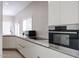 Modern kitchen boasts sleek white cabinetry, stainless steel appliances, and countertop with marble-like veining at 1731 E Evans Dr, Phoenix, AZ 85022