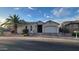 Charming single-story home boasts a stucco facade, arched entryway, attached garage, and desert landscaping at 17946 W Buena Vista Dr, Surprise, AZ 85374
