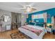 Bright bedroom with a colorful bedspread, teal accent wall, and a ceiling fan at 1822 N Sunaire Cir, Mesa, AZ 85205