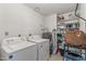 Functional laundry room featuring washer, dryer, water heater, and shelving space at 1822 N Sunaire Cir, Mesa, AZ 85205
