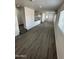 Spacious living room featuring modern gray flooring, white walls, and plenty of natural light from the windows at 2027 E Michelle Dr, Phoenix, AZ 85022
